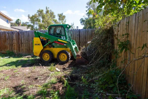 Residential Land Clearing John Deere 333G skid steer clearing overgrown fence line tight suburban backyard Riverside Jacksonville FL