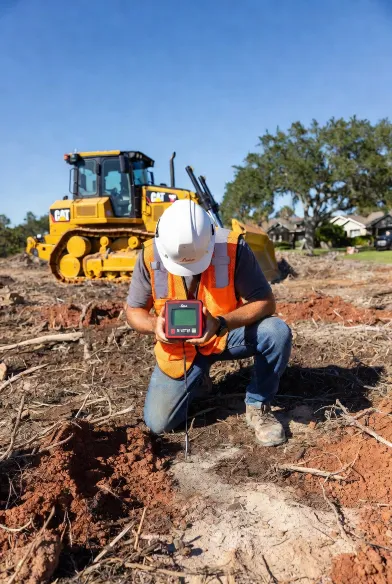 land clearing jacksonville fl crew member
performing leica disto laser depth inspection
post-clear root ball check cleared lot westside
duval county
