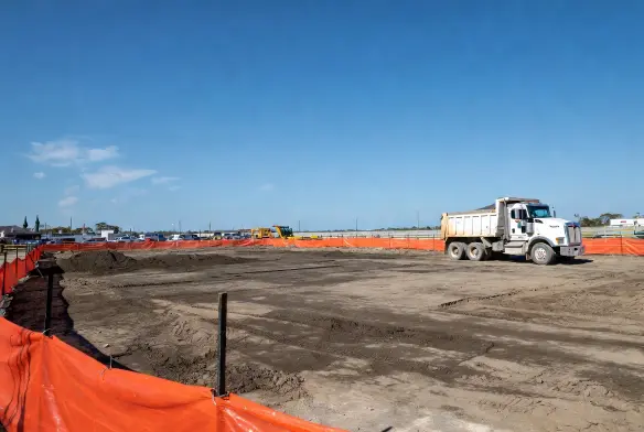 after construction cleanup southside jacksonville fl baymeadows fully cleared graded site dump truck leaving next trade arriving survey stakes visible